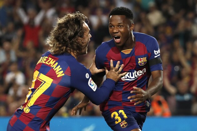 Barcelona's Ansu Fati, right, celebrates with teammate Barcelona's Antoine Griezmann after scoring the opening goal during the Spanish La Liga soccer match between FC Barcelona and Valencia CF at the Camp Nou stadium in Barcelona, Spain, Saturday, Sep. 14, 2019. (AP Photo/Joan Monfort)
