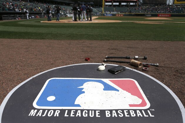 The Major League Baseball logo serves as the visitor's on deck circle before a baseball game between the Chicago White Sox and the Cleveland Indians Wednesday, April 24, 2013, in Chicago. (AP Photo/Charles Rex Arbogast)