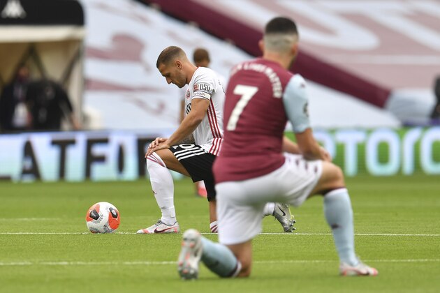 Sheffield United's Billy Sharp, left and Aston Villa's John McGinn kneel prior to the start of the English Premier League soccer match between Aston Villa and Sheffield United at Villa Park in Birmingham, England, Wednesday, June 17, 2020. The English Premier League resumes Wednesday after its three-month suspension because of the coronavirus outbreak. (Paul Ellis/Pool via AP)