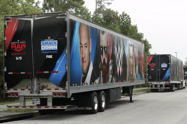 Equipment trailers are lined up at the entrance road to the WWE Performance Center Tuesday, April 14, 2020, in Orlando, Fla.  Florida’s top emergency official last week amended Gov. Ron DeSantis’ stay-at-home order to include employees at the professional sports and media production with a national audience, if the location is closed to the public. (AP Photo/John Raoux)