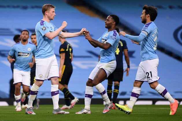 Manchester City's Belgian midfielder Kevin De Bruyne (2L) celebrates scoring his team's second goal from the penalty spot with Manchester City's English midfielder Raheem Sterling (2R) and Manchester City's Spanish midfielder David Silva during the English Premier League football match between Manchester City and Arsenal at the Etihad Stadium in Manchester, north west England, on June 17, 2020. - The Premier League makes its eagerly anticipated return today after 100 days in lockdown but behind closed doors due to coronavirus restrictions. (Photo by LAURENCE GRIFFITHS / POOL / AFP) / RESTRICTED TO EDITORIAL USE. No use with unauthorized audio, video, data, fixture lists, club/league logos or 'live' services. Online in-match use limited to 120 images. An additional 40 images may be used in extra time. No video emulation. Social media in-match use limited to 120 images. An additional 40 images may be used in extra time. No use in betting publications, games or single club/league/player publications. /  (Photo b