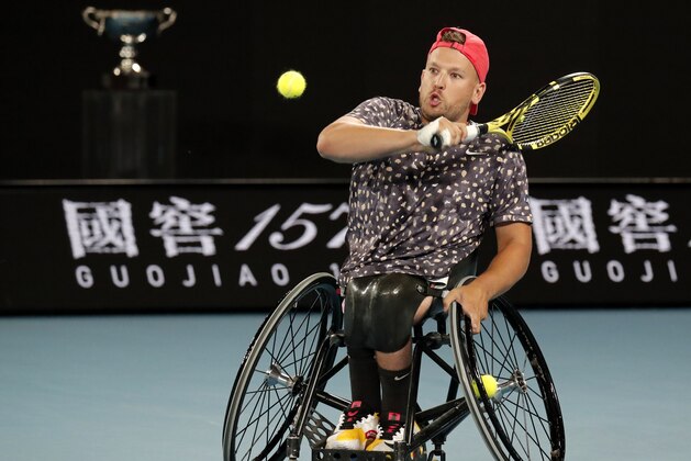 Australia's Dylan Alcott makes a backhand return to Britain's Andy Lapthorne during the men's quad wheelchair singles final at the Australian Open tennis championship in Melbourne, Australia, Saturday, Feb. 1, 2020. (AP Photo/Lee Jin-man)