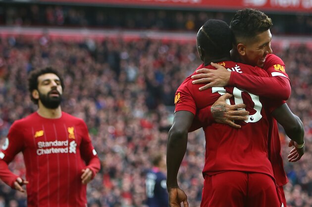 Liverpool's Senegalese striker Sadio Mane (C) celebrates with Liverpool's Brazilian midfielder Roberto Firmino (R) and Liverpool's Egyptian midfielder Mohamed Salah scoring his team's second goal during the English Premier League football match between Liverpool and Bournemouth at Anfield in Liverpool, north west England on March 7, 2020. (Photo by GEOFF CADDICK / AFP) / RESTRICTED TO EDITORIAL USE. No use with unauthorized audio, video, data, fixture lists, club/league logos or 'live' services. Online in-match use limited to 120 images. An additional 40 images may be used in extra time. No video emulation. Social media in-match use limited to 120 images. An additional 40 images may be used in extra time. No use in betting publications, games or single club/league/player publications. /  (Photo by GEOFF CADDICK/AFP via Getty Images)