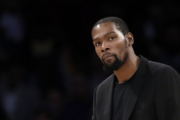 FILE- In this March 10, 2020, file photo, Brooklyn Nets' Kevin Durant watches during the second half of the team's NBA basketball game against the Los Angeles Lakers in Los Angeles. Durant is among the four Brooklyn Nets who have tested positive for the new coronavirus. (AP Photo/Marcio Jose Sanchez, file)
