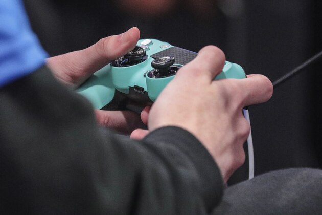 A contestant toggles a game controller during day one of the NBA 2k League (NBA2KL) professional esports playoffs, Wednesday, July 24, 2019, in Queens borough of New York. (AP Photo/Bebeto Matthews)