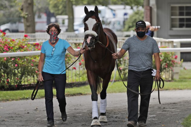 Robin Smullen, left, and Juan Barajas Saldana walk Belmont Stakes hopeful Tiz the Law around the paddock at Belmont Park in Elmont, N.Y., Thursday, June 18, 2020.  (AP Photo/Seth Wenig)