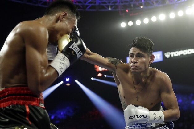 Emanuel Navarrete, right, of Mexico, punches Jeo Santisima, of the Philippines, during their super bantamweight boxing match Saturday, Feb. 22, 2020, in Las Vegas. (AP Photo/Isaac Brekken)