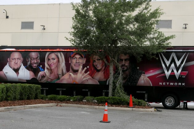 A trailer set up near a satellite truck to transmit wrestling broadcasts is parked outside the WWE Performance Center Tuesday, April 14, 2020, in Orlando, Fla. Florida’s top emergency official last week amended Gov. Ron DeSantis’ stay-at-home order to include employees at the professional sports and media production with a national audience, if the location is closed to the public.  (AP Photo/John Raoux)