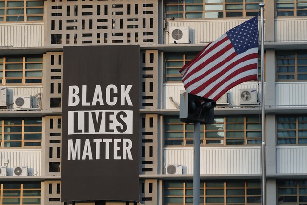 In this June 14, 2020 photo, U.S. flag flutters next to a giant Black Lives Matter banner at the U.S. Embassy in Seoul, South Korea. The banner has been removed from the U.S. Embassy building in South Korea's capital three days after it was raised there in solidarity with protesters back home.(AP Photo/Lee Jin-man) In this June 14, 2020 photo, U.S. flag flutters next to a giant Black Lives Matter banner at the U.S. Embassy in Seoul, South Korea. The banner has been removed from the U.S. Embassy building in South Korea's capital three days after it was raised there in solidarity with protesters back home.(AP Photo/Lee Jin-man)