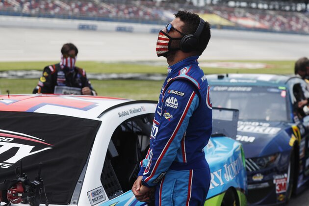 Driver Bubba Wallace stands next to his car prior to the start of the NASCAR Cup Series at the Talladega Superspeedway in Talladega, Ala., Monday, June 22, 2020. (AP Photo/John Bazemore)