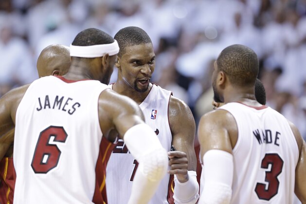 Miami Heat center Chris Bosh, center, talks with forward LeBron James (6) and guard Dwyane Wade (3) during the second half of Game 2 of an Eastern Conference semifinal basketball game against the Brooklyn Nets, Thursday, May 8, 2014 in Miami. The Heat defeated the Nets 94-82. (AP Photo/Wilfredo Lee)