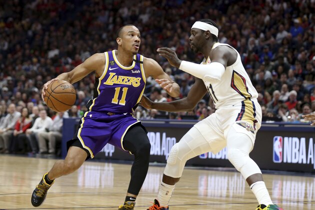 Los Angeles Lakers guard Avery Bradley (11) dribbles the ball as New Orleans Pelicans guard Jrue Holiday (11) defends in the first half of an NBA basketball game in New Orleans, Sunday, March 1, 2020. (AP Photo/Rusty Costanza)
