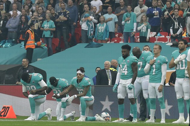 Miami Dolphins' Julius Thomas (89), Michael Thomas (31) and Kenny Stills take a knee as the U.S. national anthem is played before an NFL football game against the New Orleans Saints at Wembley Stadium in London, Sunday Oct. 1, 2017. (AP Photo/Matt Dunham)