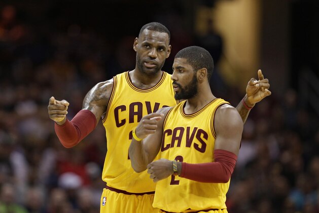 Cleveland Cavaliers' LeBron James, back, talks with Kyrie Irving in the first half of an NBA basketball game against the Orlando Magic, Saturday, Jan. 2, 2016, in Cleveland. (AP Photo/Tony Dejak)