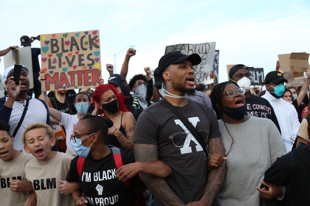 Portland Trailblazers' Damian Lillard, second from right, joins other demonstrators in Portland, Ore., during a protest against police brutality and racism sparked by the death of George Floyd, who died May 25 after being restrained by police in Minneapolis. (AP Photo/Craig Mitchelldyer)
