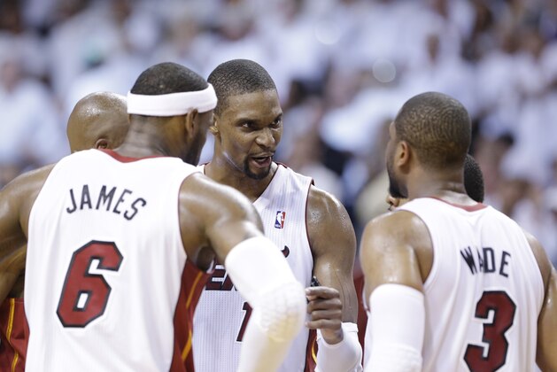 Miami Heat center Chris Bosh, center, talks with forward LeBron James (6) and guard Dwyane Wade (3) during the second half of Game 2 of an Eastern Conference semifinal basketball game against the Brooklyn Nets, Thursday, May 8, 2014 in Miami. The Heat defeated the Nets 94-82. (AP Photo/Wilfredo Lee)