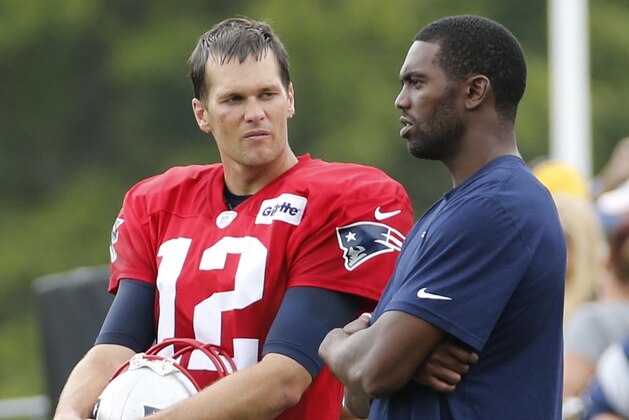 New England Patriots quarterback Tom Brady (12) talks with former wide receiver Randy Moss, right, during a joint practice between the Patriots and New Orleans Saints at the Saint's NFL football training camp in White Sulphur Springs, W.Va., Thursday, Aug. 20, 2015.  (AP Photo/Steve Helber)