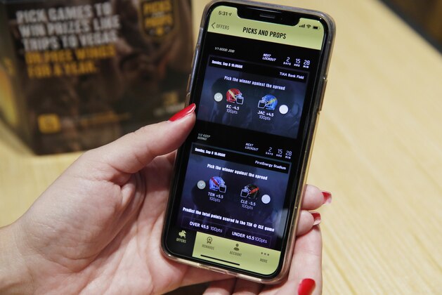 A mobile football game app is displayed at a Buffalo Wild Wings, Thursday, Sept. 5, 2019, in Las Vegas. MGM Resorts International and Buffalo Wild Wings are launching a mobile football game app for customers to pick favorite NFL teams, choose weekly fantasy performers and make proposition picks. Officials said the goal is to expand later at Buffalo Wild Wings in states where sports betting is legal through a mobile app called BetMGM. (AP Photo/John Locher) A mobile football game app is displayed at a Buffalo Wild Wings, Thursday, Sept. 5, 2019, in Las Vegas. MGM Resorts International and Buffalo Wild Wings are launching a mobile football game app for customers to pick favorite NFL teams, choose weekly fantasy performers and make proposition picks. Officials said the goal is to expand later at Buffalo Wild Wings in states where sports betting is legal through a mobile app called BetMGM. (AP Photo/John Locher)
