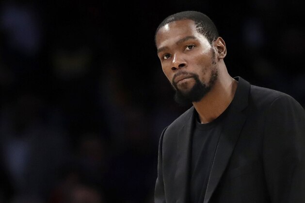 FILE- In this March 10, 2020, file photo, Brooklyn Nets' Kevin Durant watches during the second half of the team's NBA basketball game against the Los Angeles Lakers in Los Angeles. Durant is among the four Brooklyn Nets who have tested positive for the new coronavirus. (AP Photo/Marcio Jose Sanchez, file)