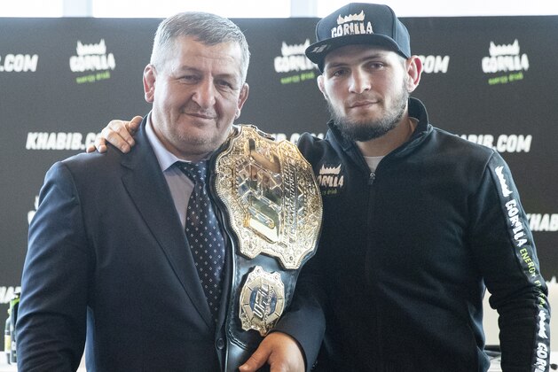 UFC lightweight champion Khabib Nurmagomedov, right, and his father Abdulmanap Nurmagomedov pose with the trophy belt during a news conference in Moscow, Russia, Monday, Nov. 26, 2018. The Russian professional mixed martial arts fighter Nurmagomedov, said he can imagine a reconciliation with Conor McGregor after the bitter feud around last month's title fight, but said he would like to fight Floyd Mayweather Jr.  (AP Photo/Pavel Golovkin)