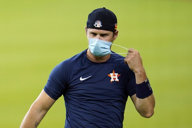 Houston Astros right fielder Josh Reddick removes his mask during a baseball practice at Minute Maid Park, Sunday, July 5, 2020, in Houston. (AP Photo/David J. Phillip)