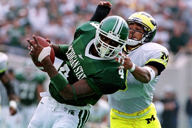Michigan State University receiver Plaxico Burress (4) pulls in a pass defended by University of Michigan cornerback Todd Howard during the second quarter at Spartan Stadium in East Lansing, Mich., Saturday, Oct. 9, 1999. Michigan State defeated Michigan 34-31.  Burress had 10 receptions for 255 yards, breaking the old school mark of 252 by Andre Rison in the 1989 Gator Bowl game against Georgia.(AP Photo/Werner Slocum)