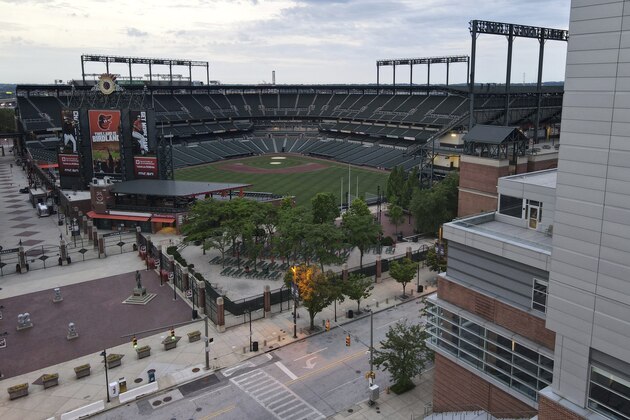 In a photo taken Saturday, June 27, 2020, an elevated deck at a Hilton hotel, right, is seen adjacent to the Oriole Park at Camden Yards stadium along West Camden Street in Baltimore. With the baseball season starting amidst coronavirus restrictions limiting fans from attending games, tall structures such as the Hilton hotel will offer a bird's eye view of games. (AP Photo/Julio Cortez)