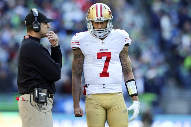 San Francisco 49ers head coach Jim Harbaugh, left, talks with quarterback Colin Kaepernick during an NFL football game against the Seattle Seahawks , Sunday, Dec. 14, 2014, in Seattle. (AP Photo/John Froschauer)