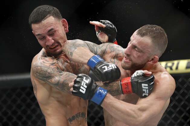 Alexander Volkanovski lands an elbow to Max Holloway in a mixed martial arts featherweight championship bout at UFC 245, Saturday, Dec. 14, 2019, in Las Vegas. (AP Photo/John Locher)