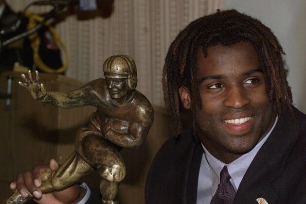 Texas tailback Ricky Williams, winner of the 1998 Heisman trophy, smiles as he holds a copy of the Heisman trophy while speaking to the media Saturday, Dec. 12, 1998 at the Downtown Athletic Club in New York. Williams ran for 2,124 yards and broke Tony Dorsett's 22-year-old record career rushing record as he led the Longhorns to an 8-3 record and a trip to the Cotton Bowl on Jan. 1.  (AP Photo/Suzanne Plunkett)