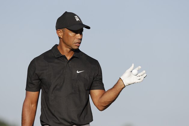 Tiger Woods catches a golf ball as he hits on the practice range before a practice round for the Memorial golf tournament, Tuesday, July 14, 2020, in Dublin, Ohio. (AP Photo/Darron Cummings)