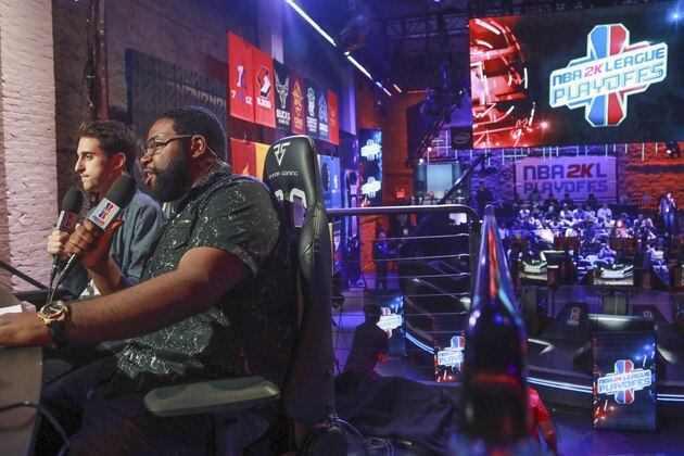 Jeff Eisenband, left, and Phil Eisu, right, live broadcast live day one of the NBA 2k League (NBA2KL) professional esports playoffs, Wednesday, July 24, 2019, in Queens borough of New York. The teams kicked off day one of the NBA2KL playoffs with Blazers on the losing 67-45. (AP Photo/Bebeto Matthews)