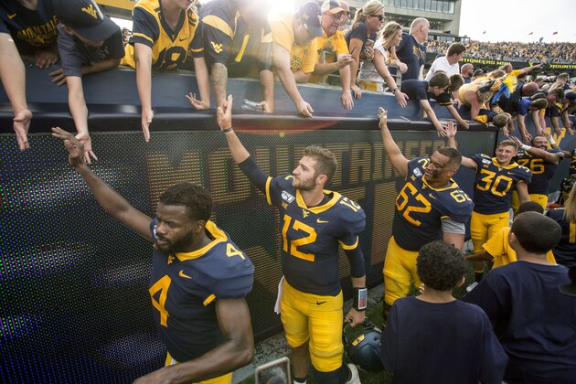 West Virginia quarterback Austin Kendall (12) celebrates with fans at the conclusion of an NCAA college football game against James Madison Saturday, Aug. 31, 2019, in Morgantown, W.Va. (AP Photo/Raymond Thompson)