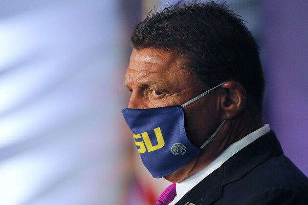Ed Orgeron, head coach of the NCAA national champion LSU football team, wears a mask as he listens to Vice President Mike Pence speak at a roundtable discussion at Tiger Stadium on the LSU campus in Baton Rouge, La., Tuesday, July 14, 2020. (AP Photo/Gerald Herbert)