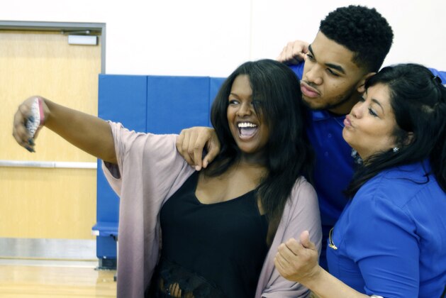 Kentucky NCAA college basketball player Karl Anthony Towns, top, poses with his girlfriend India Gentry, left, and his mother Jacqueline Cruz-Towns after Karl-Anthony announced his intent to place his name in the NBA draft during a news conference at the Joe Craft Center, Thursday, April 9, 2015, in Lexington, Ky. (AP Photo/James Crisp)