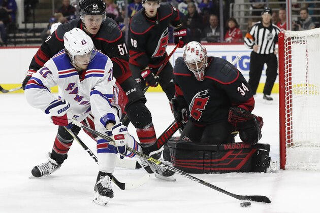 New York Rangers center Brett Howden (21) controls the puck in front of Carolina Hurricanes goaltender Petr Mrazek (34), of the Czech Republic, while Hurricanes defenseman Jake Gardiner (51) defends during the third period of an NHL hockey game in Raleigh, N.C., Friday, Feb. 21, 2020. (AP Photo/Gerry Broome)