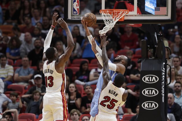 Minnesota Timberwolves guard Josh Okogie, right rear, goes up for a shot against Miami Heat forward Bam Adebayo (13) and guard Kendrick Nunn (25) during the second half of an NBA basketball game Wednesday, Feb. 26, 2020, in Miami. (AP Photo/Wilfredo Lee)