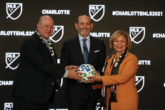 Major League Soccer Commissioner Don Garber, left, Charlotte MLS owner David Tepper, center, and Charlotte mayor Vi Lyles pose for a photo after announcing the MLS will have a team in Charlotte in 2021 at an event in Charlotte, N.C., Tuesday, Dec. 17, 2019. (AP Photo/Nell Redmond)