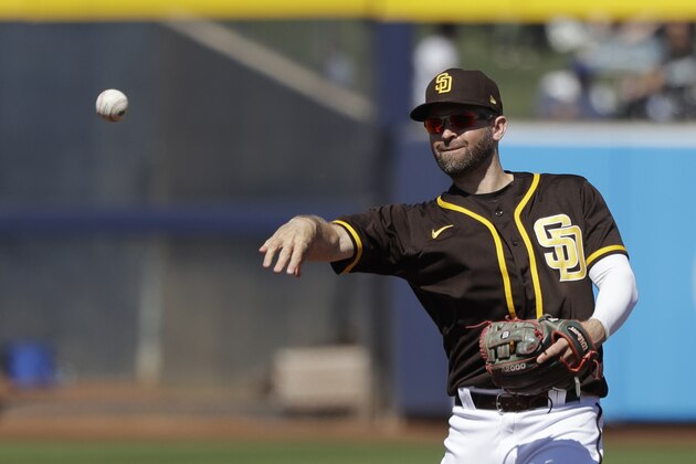 San Diego Padres second baseman Brian Dozier tosses a ball during a spring training baseball game against the Los Angeles Dodgers Monday, March 9, 2020, in Peoria, Ariz. (AP Photo/Elaine Thompson)