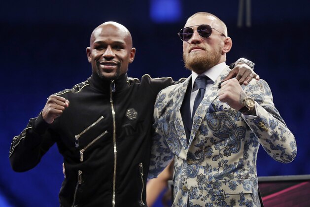 Floyd Mayweather Jr., left, and Conor McGregor pose during a news conference after a super welterweight boxing match Sunday, Aug. 27, 2017, in Las Vegas. (AP Photo/Isaac Brekken)