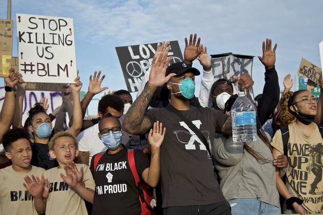 EDS NOTE OBSCENE LANGUAGE Portland Trail Blazers' Damian Lillard, center, joins other demonstrators in Portland, Ore., during a protest against police brutality and racism, sparked by the death of George Floyd, who died May 25 after being restrained by police in Minneapolis. (AP Photo/Craig Mitchelldyer)
