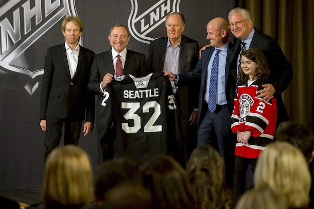 NHL commissioner Gary Bettman, center left, holds a jersey after the NHL Board of Governors announced Seattle as the league's 32nd franchise, Tuesday, Dec. 4, 2018, in Sea Island Ga.. Joining Bettman, from left to right, is Jerry Bruckheimer, David Bonderman, David Wright, Tod Leiweke and Washington Wild youth hockey player Jaina Goscinski. (AP Photo/Stephen B. Morton)