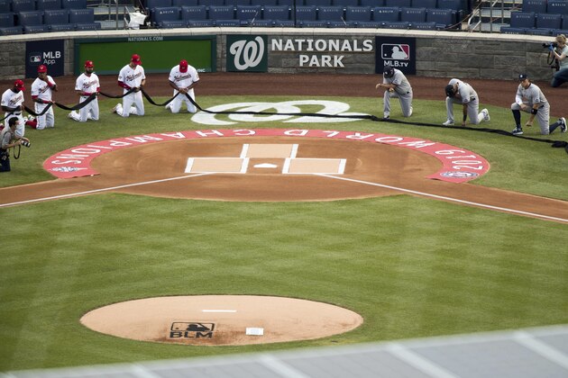 The New York Yankees and the Washington Nationals put down a black ribbon and take a knee to honor Black Lives Matter before playing an opening day baseball game at Nationals Park, Thursday, July 23, 2020, in Washington. (AP Photo/Andrew Harnik)