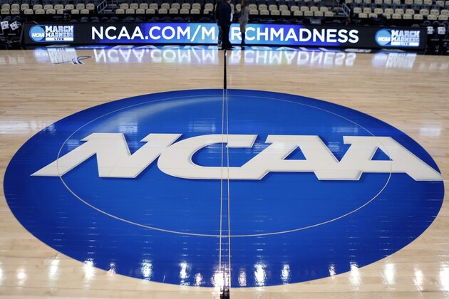 FILE - In this March 18, 2015, file photo, the NCAA logo is displayed at center court as work continues at The Consol Energy Center in Pittsburgh, for the NCAA college basketball tournament. NCAA President Mark Emmert says NCAA Division I basketball tournament games will be played without fans in the arenas because of concerns about the spread of coronavirus. (AP Photo/Keith Srakocic, File)