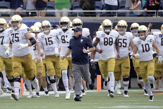 FILE - In this Dec. 28, 2019, file photo, Notre Dame head coach Brian Kelly, center, runs onto the field with his players before the Camping World Bowl NCAA college football game against Iowa State in Orlando, Fla. The Atlantic Coast Conference and Notre Dame are considering whether the Fighting Irish will give up their treasured football independence for the 2020 season play as a member of the league. (AP Photo/Phelan M. Ebenhack, File) FILE - In this Dec. 28, 2019, file photo, Notre Dame head coach Brian Kelly, center, runs onto the field with his players before the Camping World Bowl NCAA college football game against Iowa State in Orlando, Fla. The Atlantic Coast Conference and Notre Dame are considering whether the Fighting Irish will give up their treasured football independence for the 2020 season play as a member of the league. (AP Photo/Phelan M. Ebenhack, File)