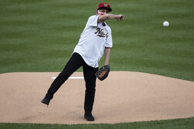 Dr. Anthony Fauci, director of the National Institute of Allergy and Infectious Diseases, throws out a ceremonial first pitch before an opening day baseball game between the Washington Nationals and the New York Yankees at Nationals Park, Thursday, July 23, 2020, in Washington. (AP Photo/Alex Brandon)