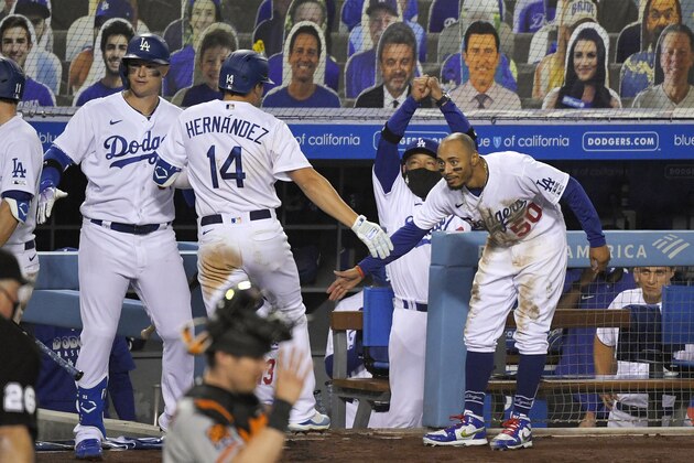Los Angeles Dodgers' Kiké Hernández (14) is congratulated by Mookie Betts, right, Joc Pederson, left, and manager Dave Roberts after hitting a two-run home run during the eighth inning of an opening day baseball game, Thursday, July 23, 2020, in Los Angeles. (AP Photo/Mark J. Terrill)