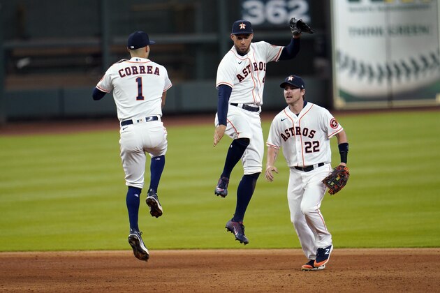 Houston Astros' Carlos Correa (1), George Springer, center, and Josh Reddick (22) celebrate after a baseball game against the Seattle Mariners Friday, July 24, 2020, in Houston. The Astros won 8-2. (AP Photo/David J. Phillip)
