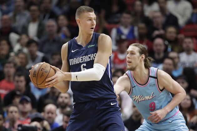 Dallas Mavericks center Kristaps Porzingis (6) looks for an open teammate past Miami Heat forward Kelly Olynyk (9) during the second half of an NBA basketball game, Friday, Feb. 28, 2020, in Miami. (AP Photo/Wilfredo Lee)