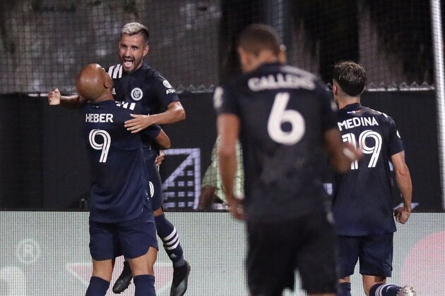 New York City FC midfielder Maximiliano Moralez is hoisted up by forward Heber (9) after scoring a goal during the second half of an MLS soccer match against Toronto FC, Sunday, July 26, 2020, in Kissimmee, Fla. (AP Photo/John Raoux)